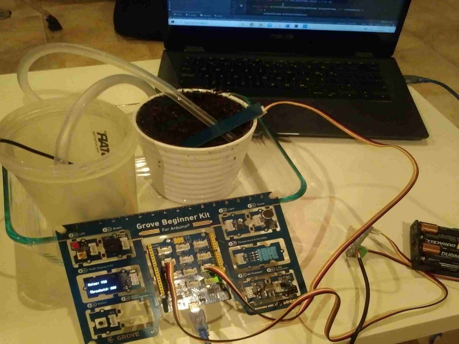 The automated plant watering system, consisting of a laptop, and Arduino board, a moisture sensor, and a pump